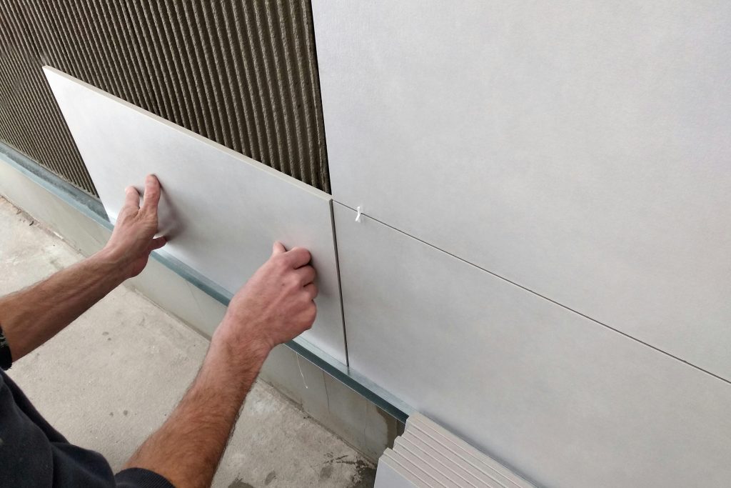 In wall pest control - Man putting white panels on wall